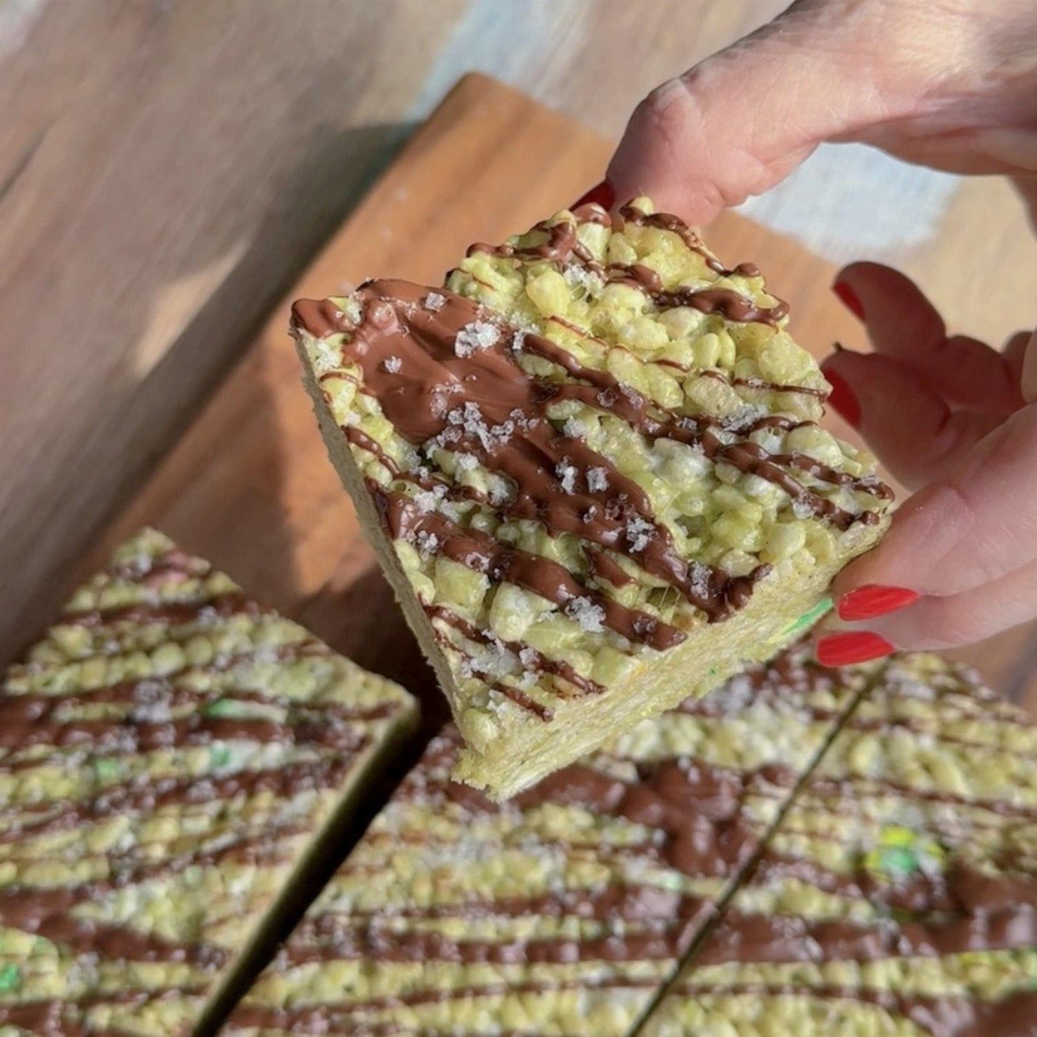 Hand holding Matcha Rice Krispies Treat dessert, garnished with Fleur de Sel Celtic Sea Salt